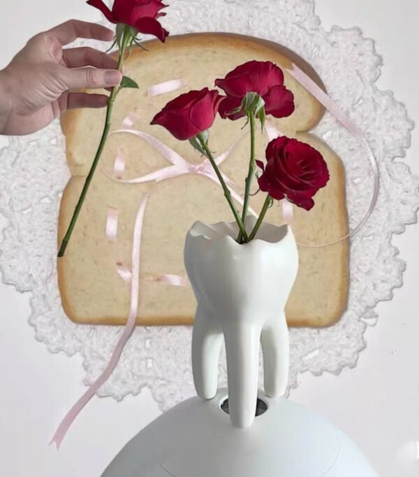 Interesante jarrón con forma de diente que se puede utilizar para arreglos florales como portavelas o para el hogar