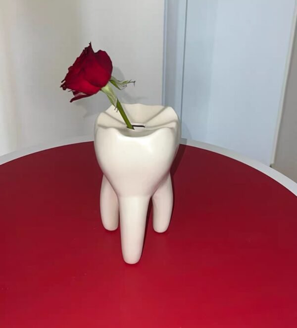 Interesante jarrón con forma de diente que se puede utilizar para arreglos florales como portavelas o para el hogar