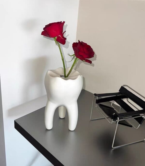 Interesante jarrón con forma de diente que se puede utilizar para arreglos florales como portavelas o para el hogar