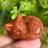 Gato dormido tallado en Goldstone naranja